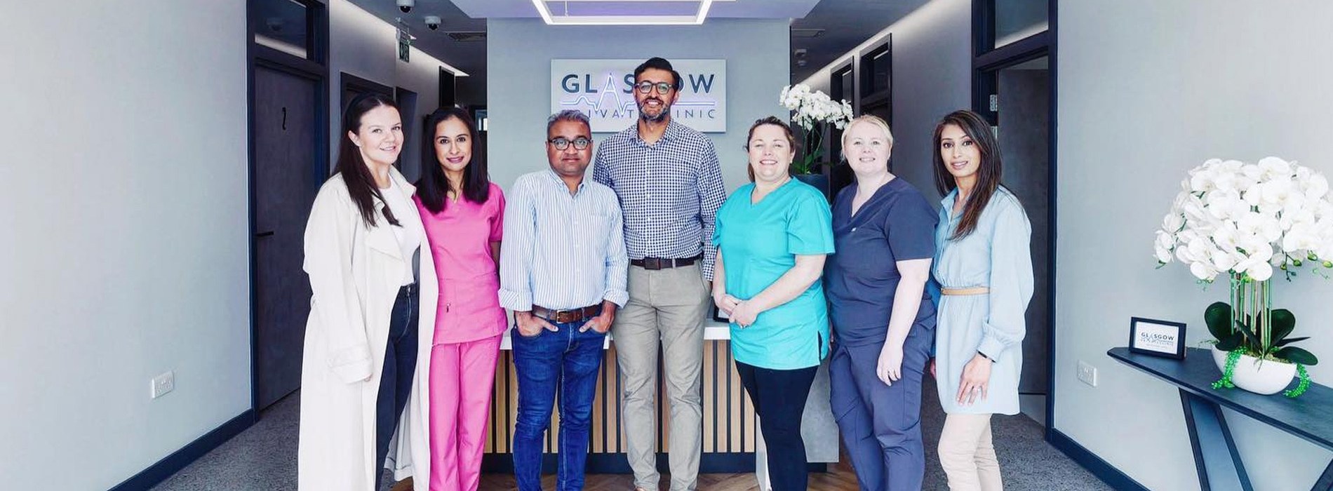 The reception and nursing team at the front desk beneath the Glasgow Private Clinic sign